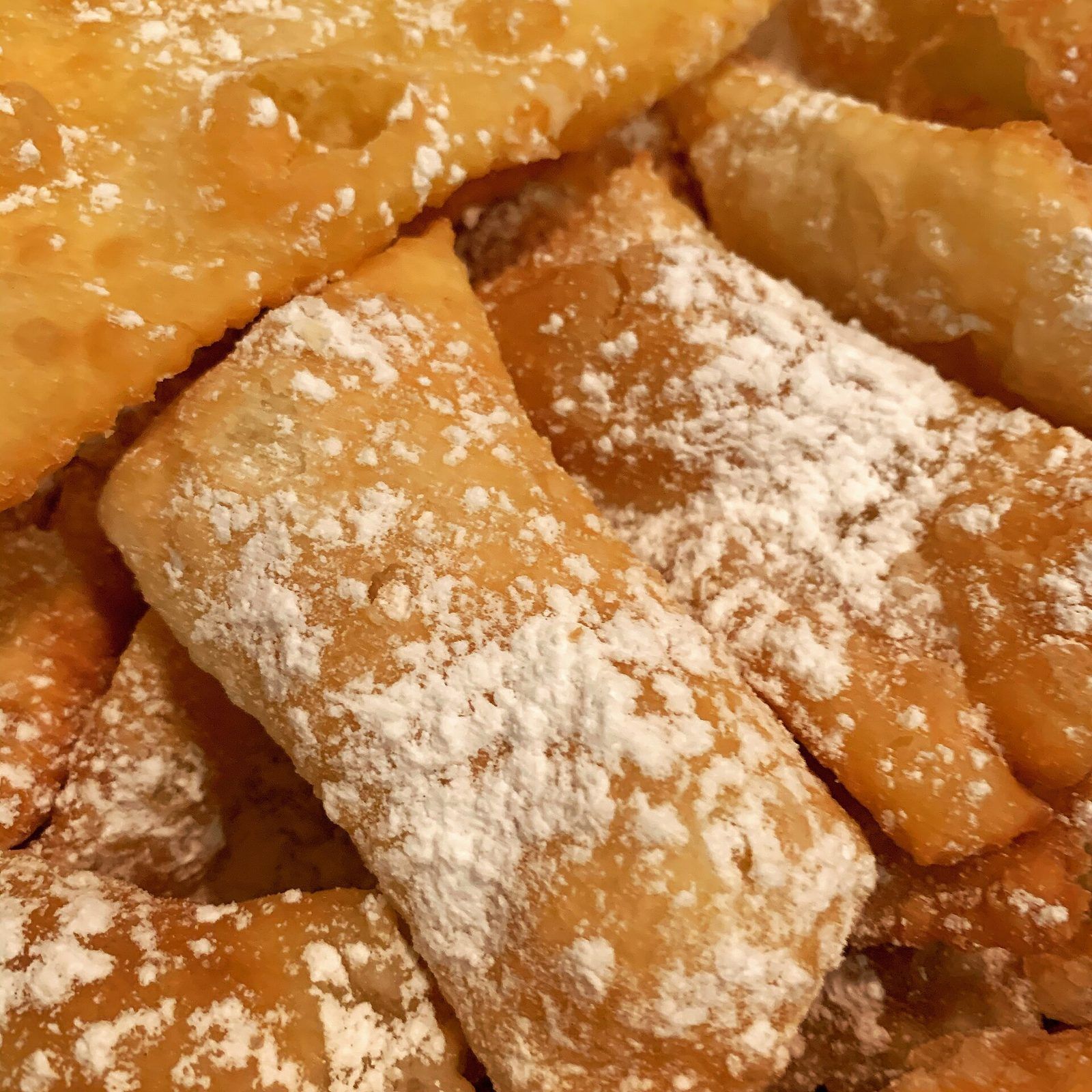 Close-up of crisp carnival fritters dusted with icing sugar